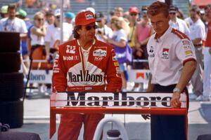 Emerson Fittipaldi and an aerodynamicist discuss setup in the paddock.