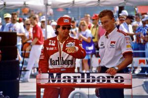 Emerson Fittipaldi and an aerodynamicist discuss setup in the paddock.