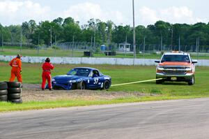 Samantha Silver's Spec Miata Mazda Miata gets pulled from the gravel trap at turn 12.