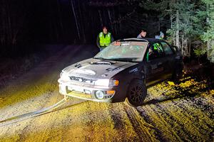 Jordan Locher / Tom Addison Subaru Impreza 2.5RS is pulled from the woods after rolling on SS1.