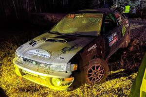 Jordan Locher / Tom Addison Subaru Impreza 2.5RS is pulled from the woods after rolling on SS1.