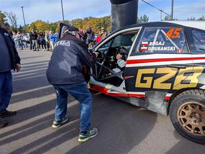 Bartek Stypa photographs the Grzegorz Bugaj / Ela Dziubanski Subaru WRX STi at the ceremonial start.