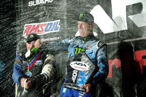 Paul Rowley and Ken Block spray champagne on the winners' podium.