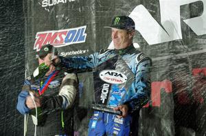 Paul Rowley and Ken Block spray champagne on the winners' podium.