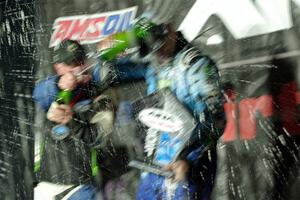 Paul Rowley and Ken Block spray each other on the winners' podium.