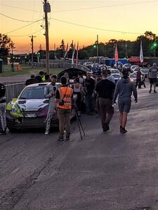 Patrick Gruszka (/ Florian Barral) is interviewed in front of his Mitsubishi Mirage RS after the event.
