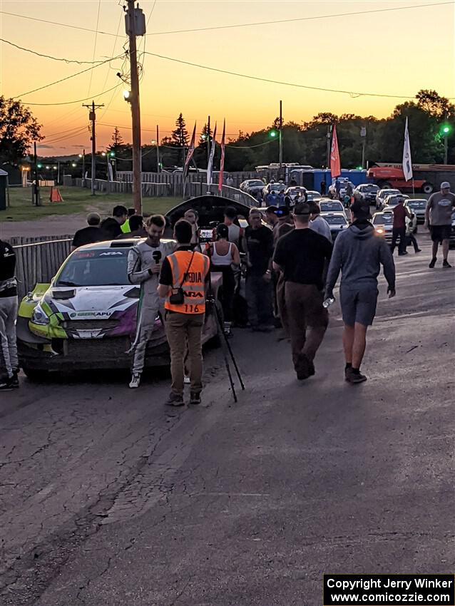 Patrick Gruszka (/ Florian Barral) is interviewed in front of his Mitsubishi Mirage RS after the event.