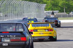 and Dan Little's American Sedan Ford Mustang head for the track exit.