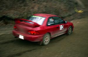 Piotr Wiktorczyk / Ray Summers drift through a sweeper on SS1 in their Subaru Impreza.