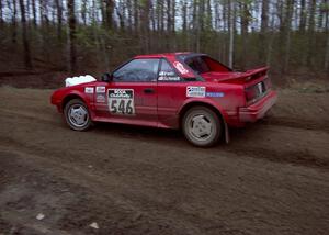 Steve Irwin	/ Phil Schmidt power out of a 90-left on SS2 in their Toyota MR2.