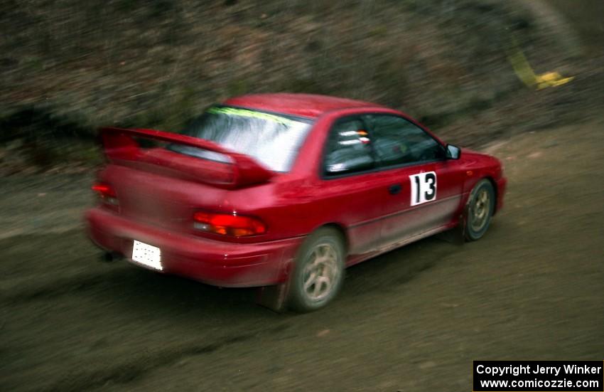 Piotr Wiktorczyk / Ray Summers drift through a sweeper on SS1 in their Subaru Impreza.