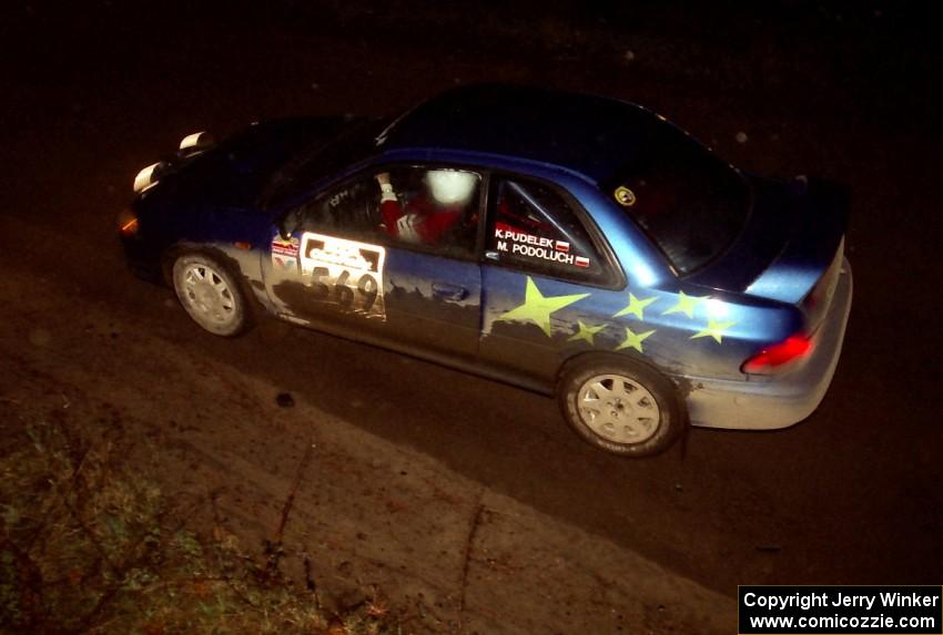 Kazimierz Pudelek / Mark Pudoluch drift through a fast sweeper at night in their Subaru Impreza.