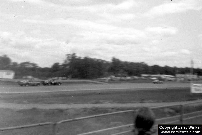 Three cars head down the front straight early on during the race.