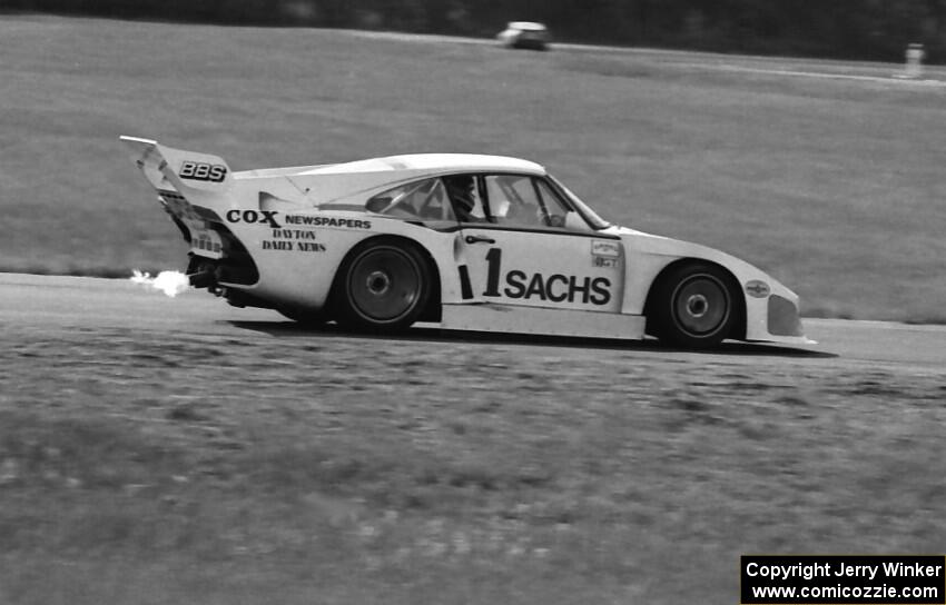 John Fitzpatrick's Porsche 935 shoots flames coming into turn four.