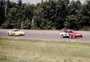 Logan Blackburn's Datsun 280XZ leads the Roger Mandeville / Amos Johnson Mazda RX-7 through turn 1.