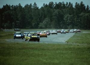 Kal Showket's Mazda GLC and Joe Varde's Dodge Charger lead the rest of the field through turns 3 and 4.