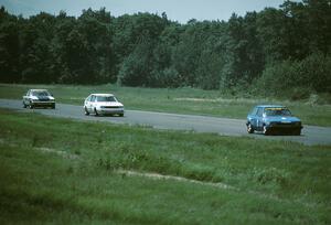 Chuck Ulinski's Mazda 323 leads Joe Nonnamaker's Nissan Stanza and Doug Peterson's Renault Alliance into turn 4.