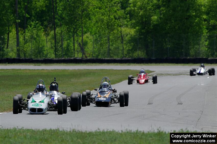 The vintage formula car field comes between turns three and four on lap one.