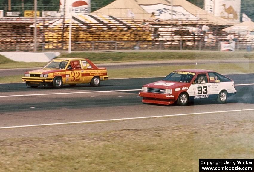 Bobby Archer's Renault Alliance and Dave Frellson's Nissan Sentra go side-by-side down the front straight.