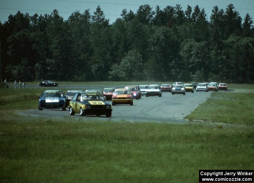 Kal Showket's Mazda GLC and Joe Varde's Dodge Charger lead the rest of the field through turns 3 and 4.