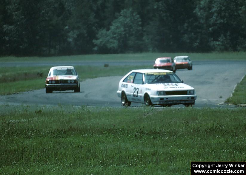 Tom Schneider's Nissan Stanza leads John Poulos's BMW 320i, Ron Tambourine's Mazda RX-3 and Ralph Schreyer's Mercury Capri II.