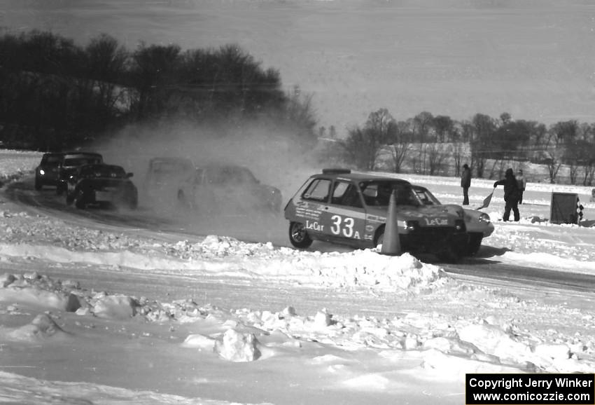 Tommy Archer's Renault LeCar leads Steve Erickson's SAAB Sonett II and the rest into turn one on the first lap.