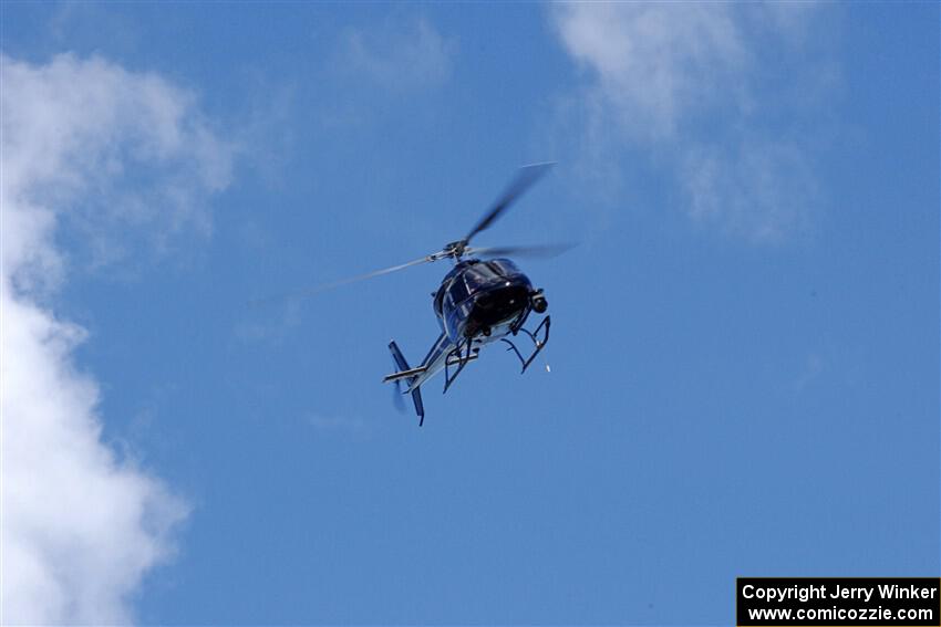 An helicopter flies high above turn one during the Porsche GT3 Cup race.