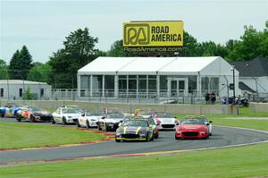 The field of Mazda MX-5 Cup cars fronted by Selin Rollan and Gresham Wagner head through turn 14 on the pace lap.