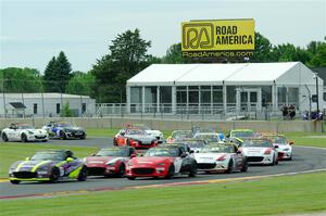 The field of Mazda MX-5 Cup cars fronted by Selin Rollan and Gresham Wagner head out of turn 14 on the pace lap.