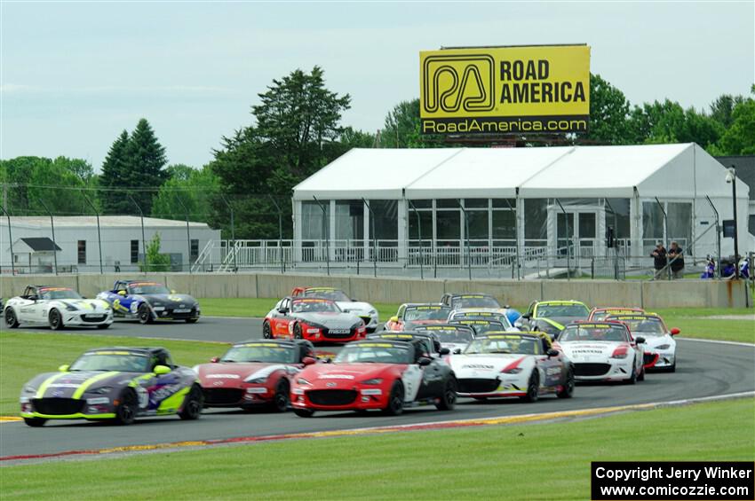 The field of Mazda MX-5 Cup cars fronted by Selin Rollan and Gresham Wagner head out of turn 14 on the pace lap.