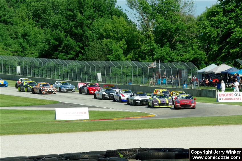 Mazda MX-5 Cups stream into turn 3 on lap one, with Selin Rollan and Michael Carter leading the way.