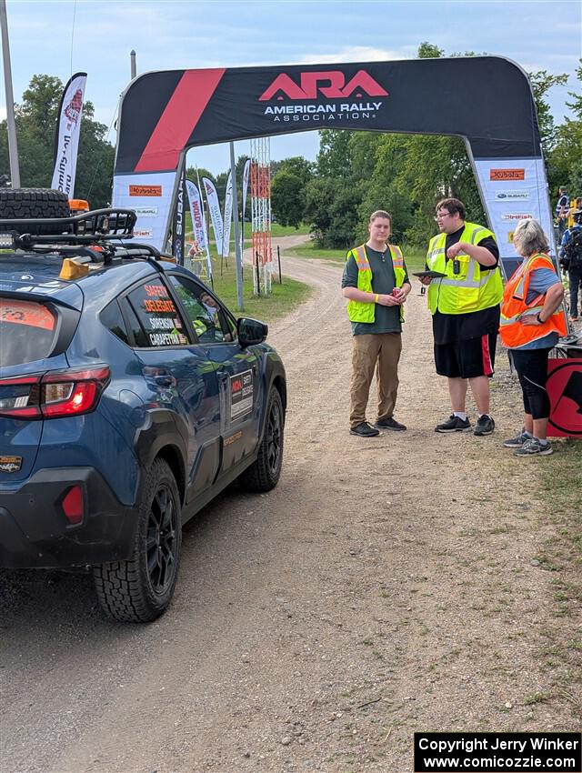 The 'Safety Delegate' car, a Subaru Crosstrek, pulls into the start of SS1, Soo Pass I.