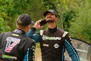 John Hall sprays insect repellant on Patrick Gruszka after their Hyundai i20 R5 stalled on SS11, Otterkill I.