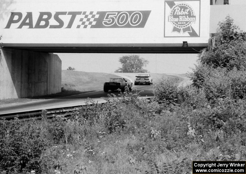 Jack Buchinger's Datsun 280ZX and Rick Anderson's Chevy Corvette pass under the turn 13 bridge.