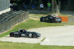 Parker Kligerman's Mazda MX-5 Cup gets stuck in the gravel. John Jodoin pulls off course.
