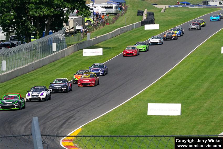 The field streams down the Hurry Downs into turn 8, on lap 1 of race 2.