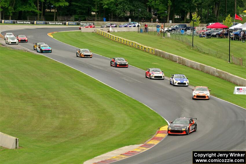 The field of Toyota GR86s streams through the Hurry Downs on lap 1 of race 1.