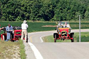 Gregory Gumtow's 1904 Overland is stopped on a hill as Jerry Johnson's 1908 Maxwell passes by.