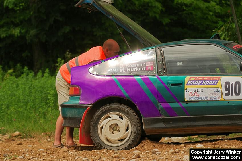 A course marshal repairs a battery issue on the Maegan Burkart / Joanna Seaman Honda CRX Si on SS2, Skunk Creek.