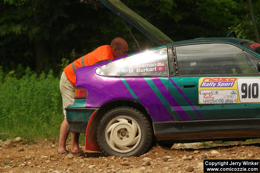 A course marshal repairs a battery issue on the Maegan Burkart / Joanna Seaman Honda CRX Si on SS2, Skunk Creek.