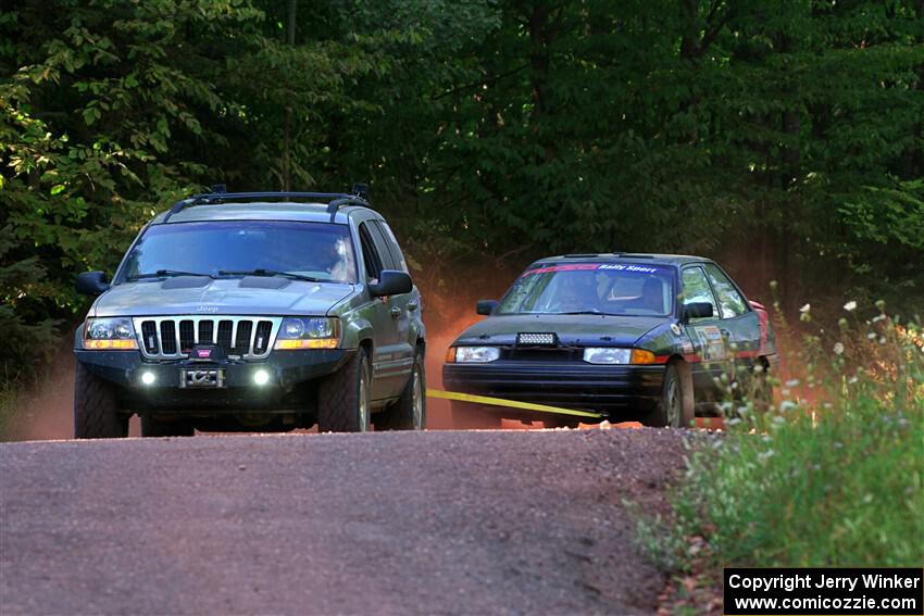 A Jeep Grand Cherokee sweeps the Joe Boburka / Elizabeth Unglenieks-Ploeg Ford Escort from SS5, Norway South II.