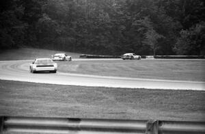 Tom Gloy's Mercury Capri ahead of Chris Kneifel's Mercury Capri and Elliott Forbes-Robinson's Buick Somerset in the carousel.