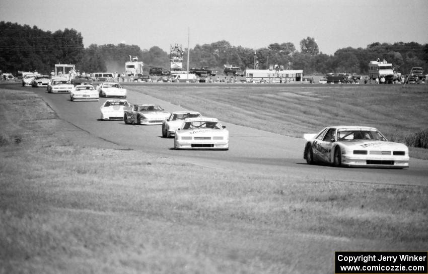 The field streams through turns 6 and 7 on the pace lap.