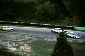 Dennis Shaw's Mazda 323, Amos Johnson's Mazda 626 and Dave Jolly's Mazda 323 out of the carousel on the pace lap
