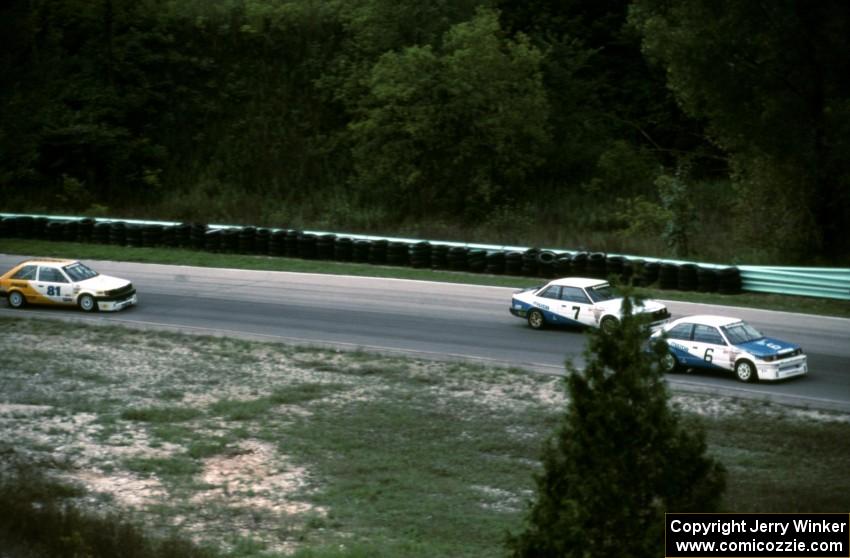 Dennis Shaw's Mazda 323, Amos Johnson's Mazda 626 and Dave Jolly's Mazda 323 out of the carousel on the pace lap