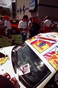 Garen Shrader is interviewed by Andy Shupack while Michael Fennell signs autographs on their Mitsubishi Lancer Evo IV