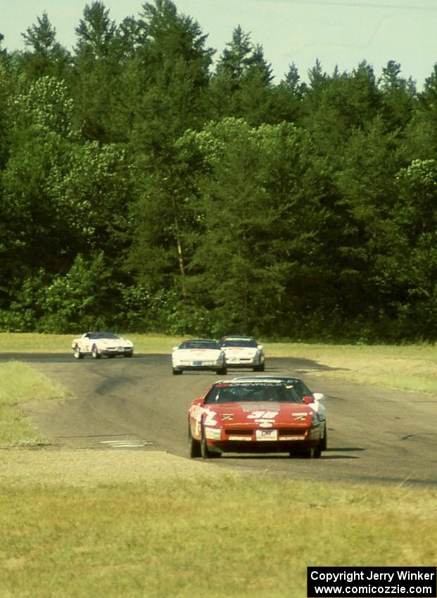 Bill Cooper chased by a number of unidentified DR Motorsports Chevy Corvettes