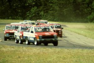 Don Marcum's, Ray Kong's and Jeff Krosnoff's Nissan Pickups lead the field through turn four.