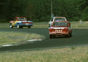 Tom Nields' Dodge Ram D-50 leads Chuck Hemmingson's Jeep Comanche and Larry Nuber's Jeep Comanche through turn 4.