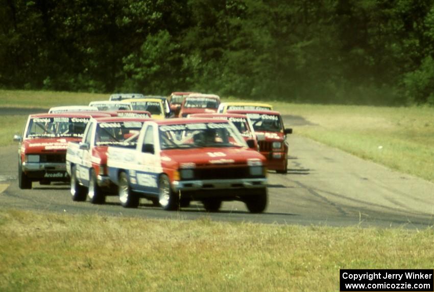 Don Marcum's, Ray Kong's and Jeff Krosnoff's Nissan Pickups lead the field through turn four.